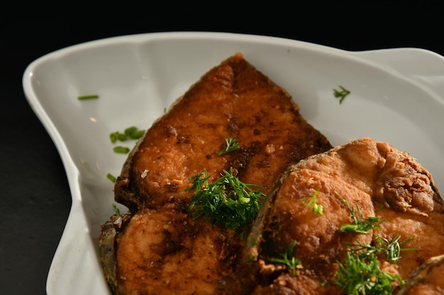 Ein Teller mit Schweinekoteletts mit einem Zweig Dill darauf