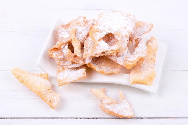 Ein Teller mit zuckerhaltigem Gebäck mit Puderzucker darauf