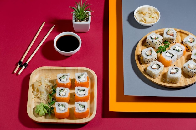 Ein Teller Sushi und eine kleine Pflanze auf einem roten Tisch