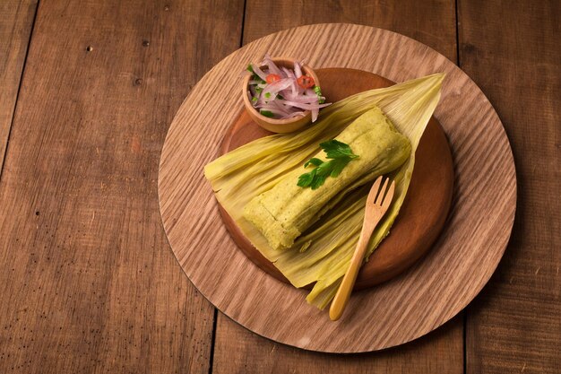 Ein Teller Tamales mit einer Schüssel Koriander und einer kleinen Schüssel Koriander.