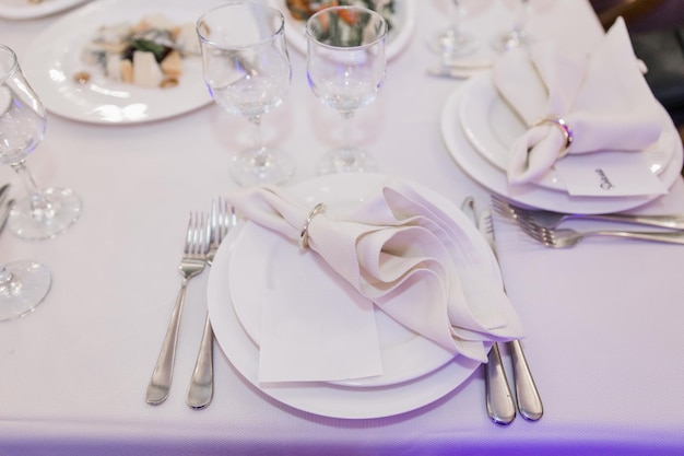 Ein Tellermesser und eine Gabel auf einem festlich gedeckten Tisch in einem Restaurant bei einer Hochzeit