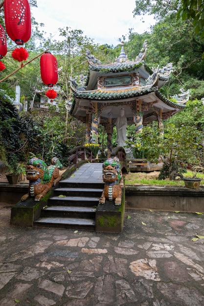 Foto ein tempel im wald mit einer drachenstatue im vordergrund