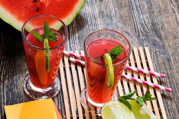 Ein Tisch mit Essen und roten reifen Wassermelonen, aus denen ein leckerer und gesunder Wassermelonensaft hergestellt wird