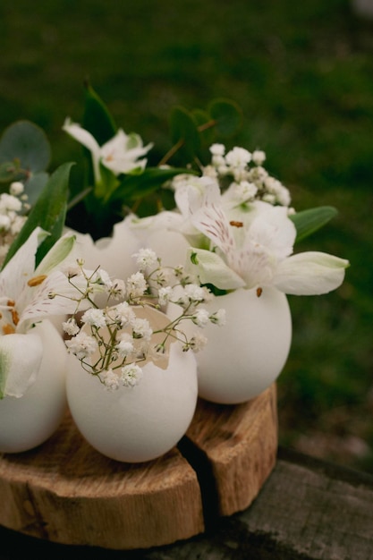 Ein Tisch mit weißen Blumenvasen darauf