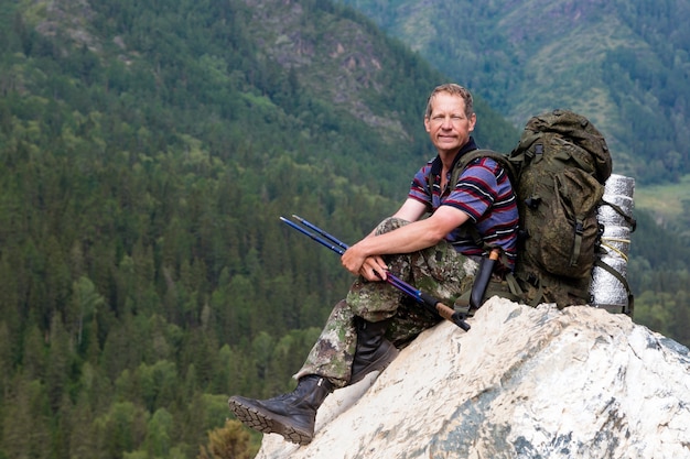 Ein Tourist auf einem hohen Berg betrachtet Natur.