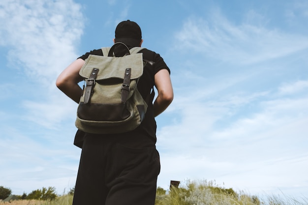 Ein Tourist mit Rucksack steigt auf einen Berg