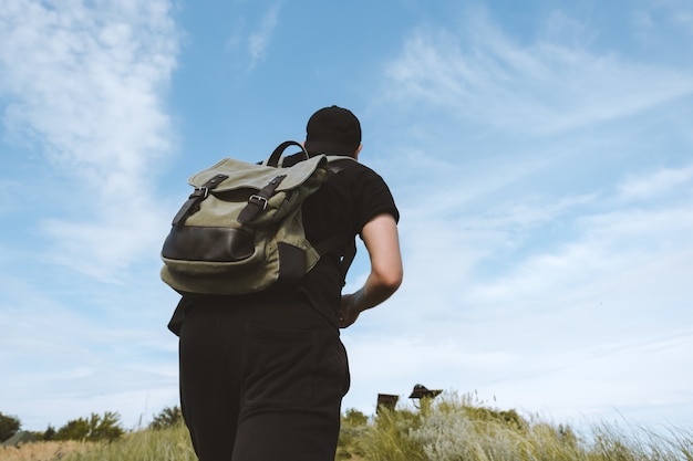 Ein Tourist mit Rucksack steigt auf einen Berg