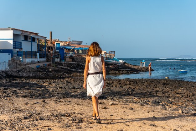 Ein Tourist zu Fuß im Fischerdorf Majanicho, nördlich der Insel Fuerteventura, Kanarische Inseln. Spanien