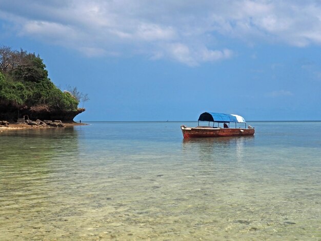 Foto ein touristisches kleines boot auf ruhigem wasser in der nähe einer tropischen insel