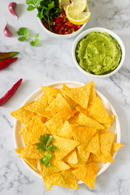 Foto ein traditioneller mexikanischer snack nachos serviert mit saucen von guacamole, pico de gallo oder salsa.