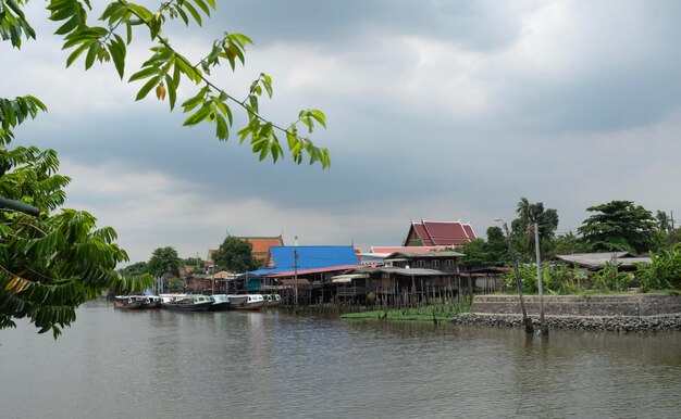 Ein traditionelles altes Haus am Fluss mit Booten, die an Kreativität vorbeifahren
