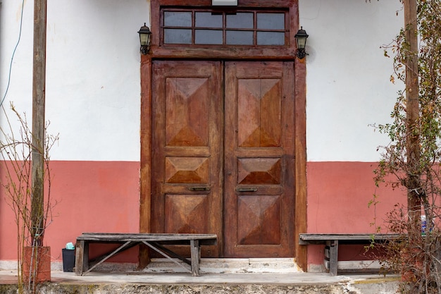 Ein traditionelles hölzernes Dorfhaus am Schwarzen Meer mit zwei Türen und Holzbänken auf beiden Seiten