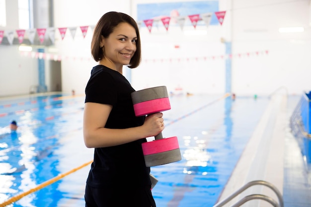 Ein Trainer in der Nähe des Sportschwimmbeckens trainiert Aqua-Aerobic