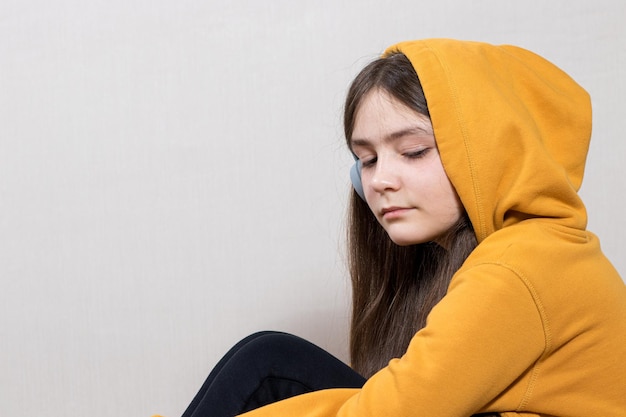 Ein trauriges Teenager-Mädchen Jahre alt sitzt in einem Kapuzen-Sweatshirt