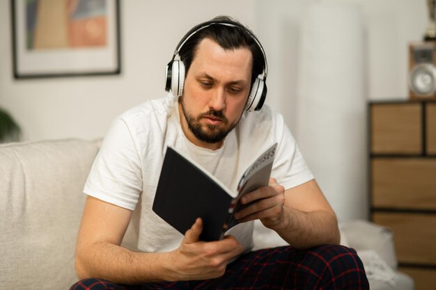 Ein Typ im Pyjama hört in seinem Zimmer entspannende Musik über Bluetooth-Kopfhörer