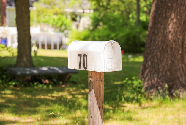 Ein uriger Briefkasten steht vor einem charmanten Haus und symbolisiert Kommunikationsverbindung und so