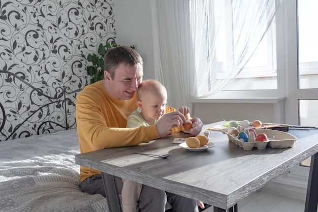 Ein Vater feiert mit seinem kleinen Sohn Ostern. Sie schlagen Eier, essen Eier und frühstücken. Vater lehrt das Kind