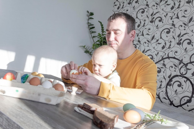 Ein Vater feiert mit seinem kleinen Sohn Ostern. Sie schlagen Eier, essen Eier und frühstücken. Vater lehrt das Kind