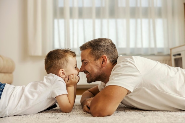 Ein Vater und sein Sohn reiben sich die Nase und verbinden sich zu Hause