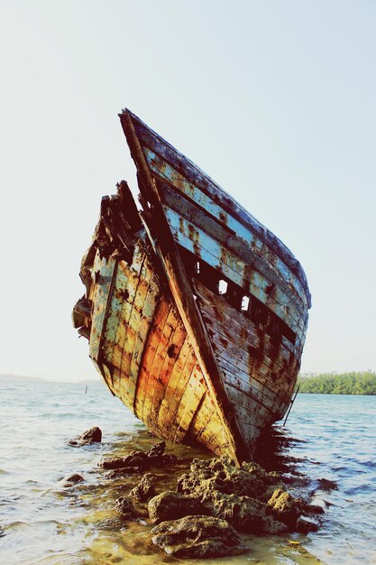 Foto ein verlassenes boot auf dem meer gegen einen klaren himmel