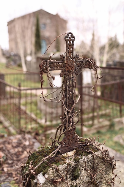 Ein verlassenes Grab mit einem rostigen Kreuz auf einem Friedhof