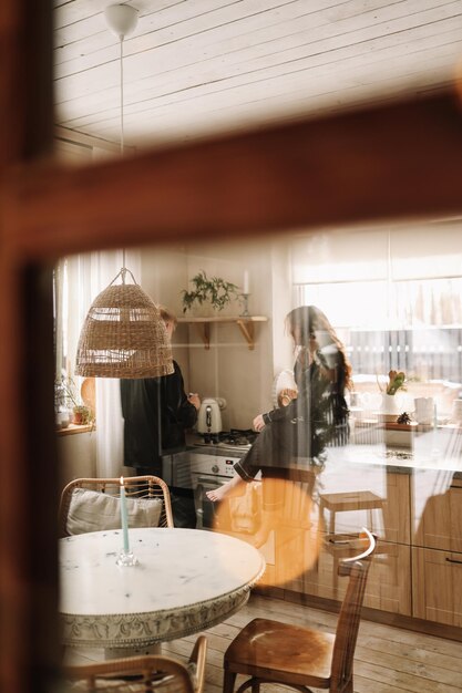 Ein verliebtes Paar frühstückt und trinkt Tee in einer geschmückten Küche im Öko-Stil in einem Landhaus