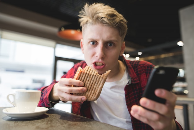 Ein verrückter Student isst in einem Café.