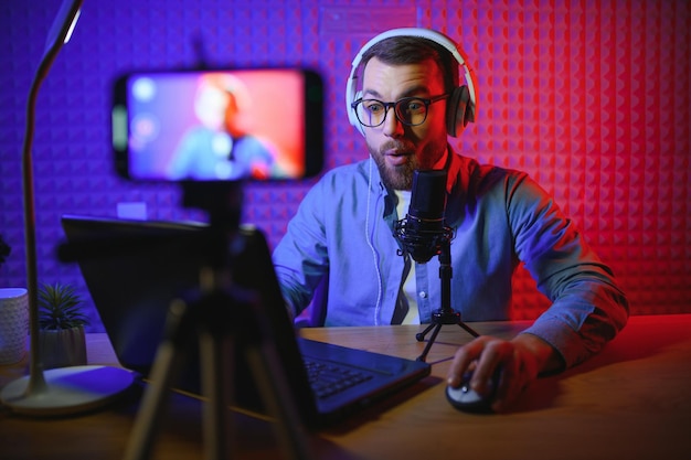 Ein Videoblogger nimmt in seinem Studio Inhalte auf Der Host des Videoblogs ist ein junger Mann, der seinen Abonnenten mit großer Begeisterung eine Geschichte erzählt