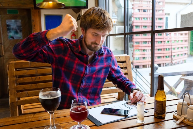 Ein von seinem Job entlassener Mann sitzt in einer Bar und trinkt ein starkes alkoholisches Getränk