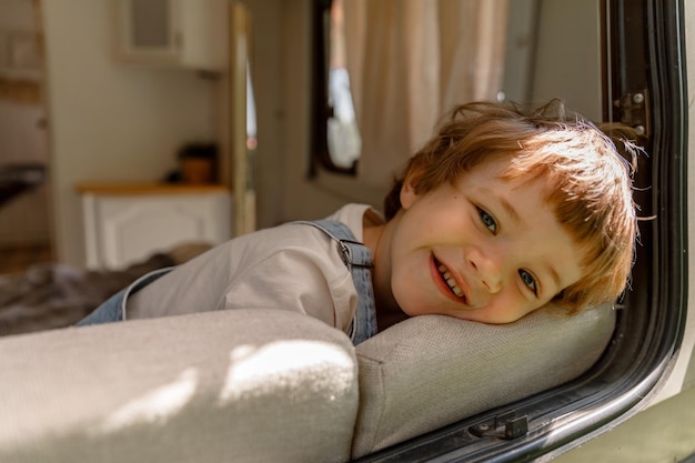 ein vorschuljunge genießt den sommer neben dem wohnmobil