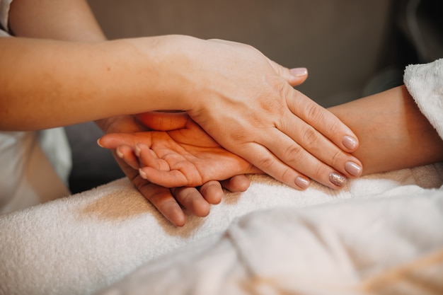 Foto ein vorsichtiger masseur massiert die hand des kunden, bevor er mit dem nächsten verfahren beginnt