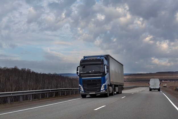 Ein Wagen fährt auf einer leeren Straße auf dem Land