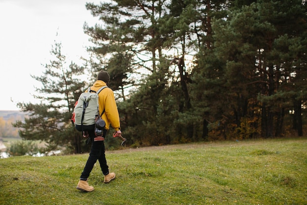 Ein Wanderer, der mit Rucksack in der Natur spaziert