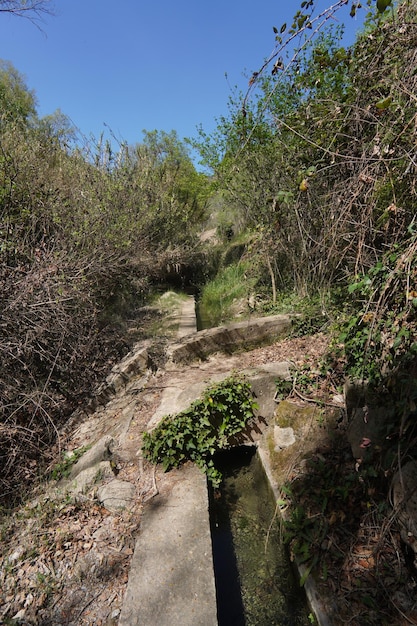 Ein Wanderweg in den Bergen mit einem kleinen Wasserspiel.