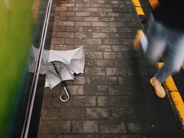 Foto ein weggeworfener regenschirm auf dem bahnsteig einer belebten bushaltestelle