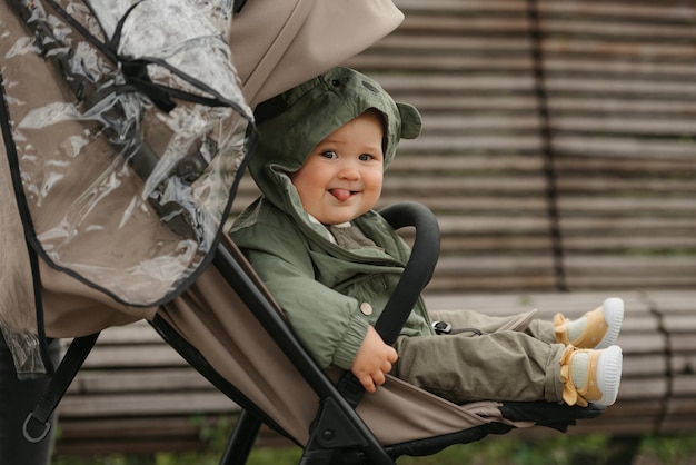 Ein weibliches Kleinkind sitzt an einem bewölkten Tag im Kinderwagen