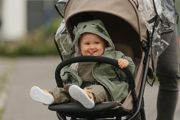 Ein weibliches Kleinkind sitzt an einem bewölkten Tag im Kinderwagen