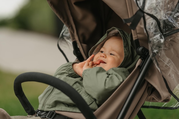 Ein weibliches Kleinkind sitzt an einem bewölkten Tag im Kinderwagen