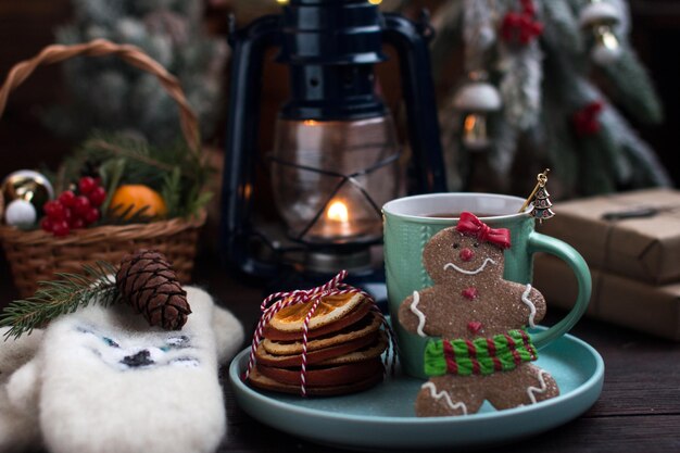 Ein Weihnachtsbaum mit Spielzeug und eine heiße Tasse Orangentee warme weiße Handschuhe und ein Lebkuchenmann