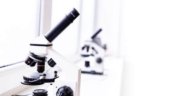 ein weißes Mikroskop auf dem Tisch ein wissenschaftliches Labor Labor der medizinischen Wissenschaften durchschauen
