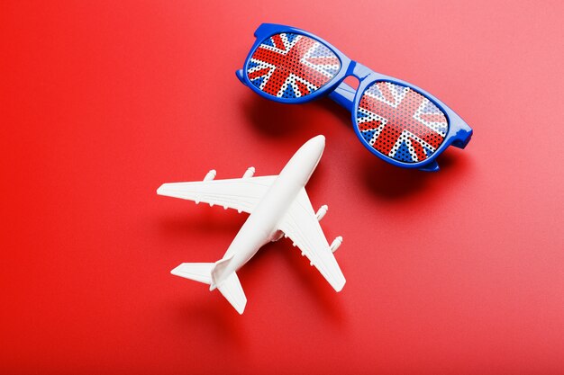 Ein weißes Passagierflugzeug fliegt in Sonnenbrille mit der Flagge des Vereinigten Königreichs ,.