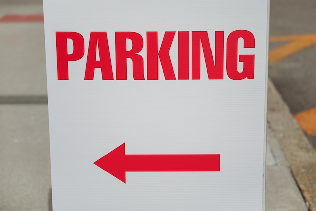 Ein weißes Schild mit einem roten Pfeil, der nach rechts zeigt.