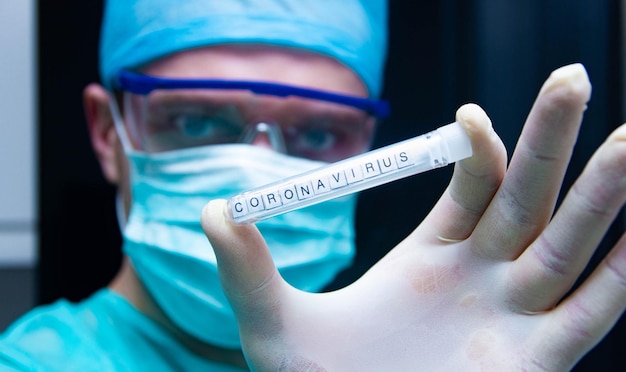 Ein Wissenschaftler hält ein Reagenzglas mit dem Virus Coronavirus in der Hand.