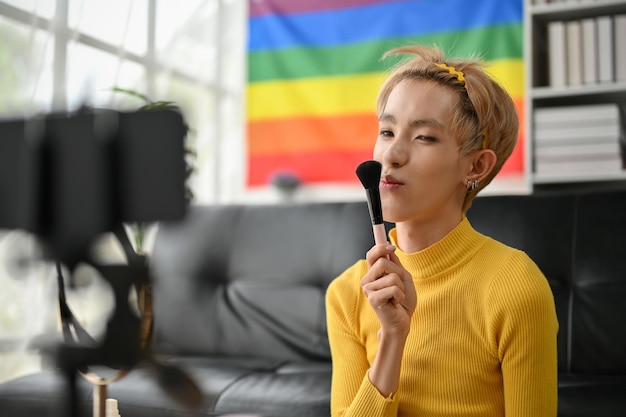 Ein wunderschöner und selbstbewusster junger asiatischer Gay-Beauty-Blogger, der sein Make-up-Tutorial-Video aufnimmt