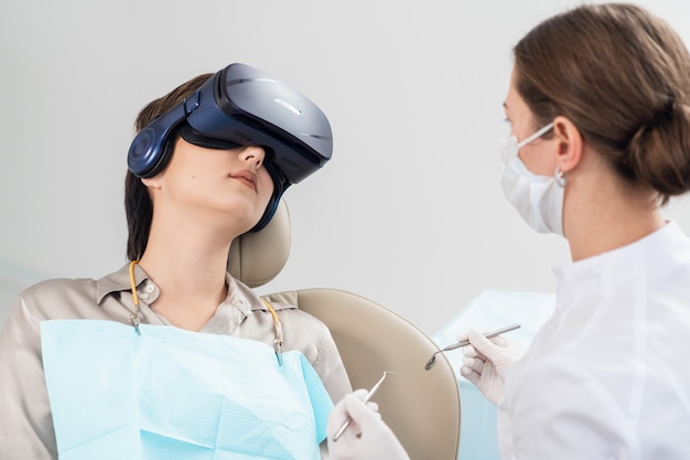 Ein Zahnarzt untersucht die Zähne des Patienten mit einer VR-Brille