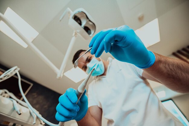 Ein Zahnarzt untersucht einen Patienten in einer modernen Zahnarztpraxis mit zahnärztlichen Instrumenten. Foto in hoher Qualität