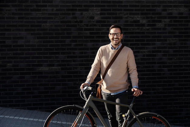 Ein zeitgenössischer Geschäftsmann, der mit Fahrrad auf der Straße posiert