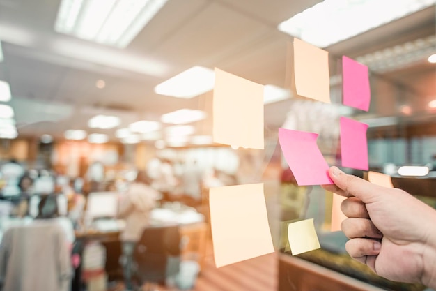 Ein Zettel an der Glaswand im Büro steht für Brainstorming. Operative Geschäftsstrategie Treffen, um Wege zu finden, um Geschäfte zu machen, um besser als zuvor zu sein.