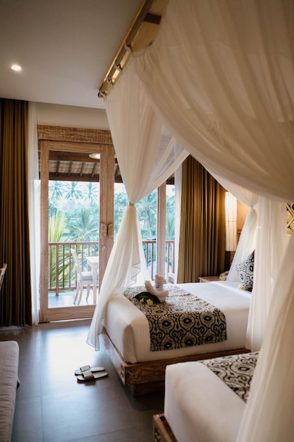 Ein Zimmer mit Balkon und einem Bett mit Baldachin über dem Bett.