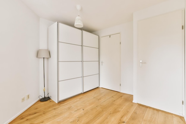 Ein Zimmer mit weißen Schränken und einem Holzboden